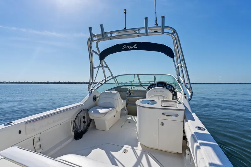 Slide: The Image of 2005 Sea Ray 270 Amberjack boat interior with seating and helm, on calm water. - 10
