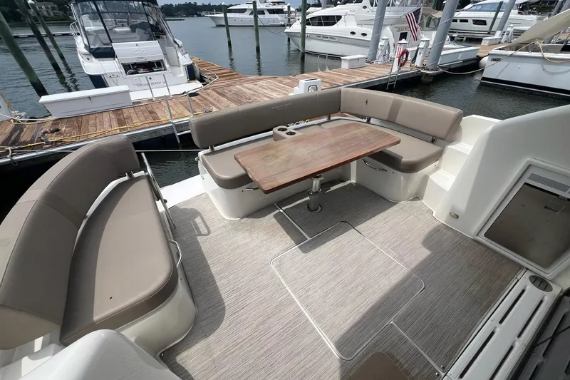 Slide: The Image of 2019 Carver C37 yacht deck with seating and wooden table at marina. - 18