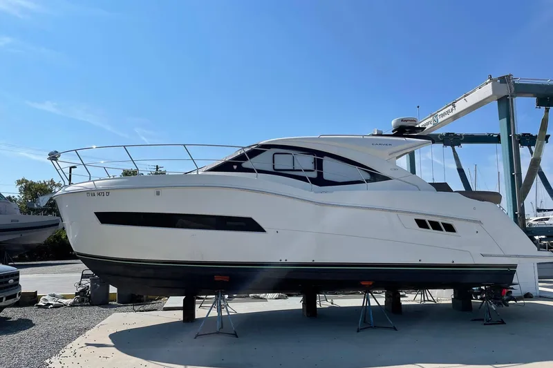 Slide: The Image of 2019 Carver C37 yacht on stands at a marina under clear blue sky. - 6