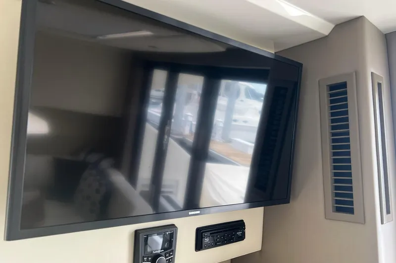 Slide: The Image of Interior of 2019 Carver C37 yacht featuring a mounted flat-screen TV and audio system. - 29