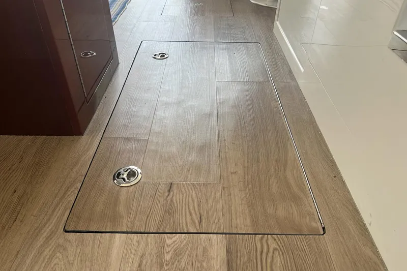 Slide: The Image of Wooden floor hatch on 2019 Carver C37 yacht, featuring sleek metal handles. - 35
