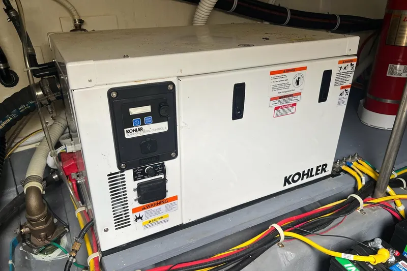 Slide: The Image of Kohler generator in a 2019 Carver C37 yacht engine room, surrounded by wiring and safety labels. - 42