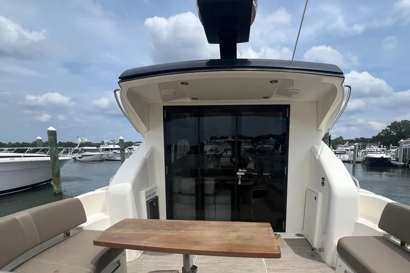 Slide: The Image of 2019 Carver C37 yacht's rear deck with seating and table, docked at marina. - 15