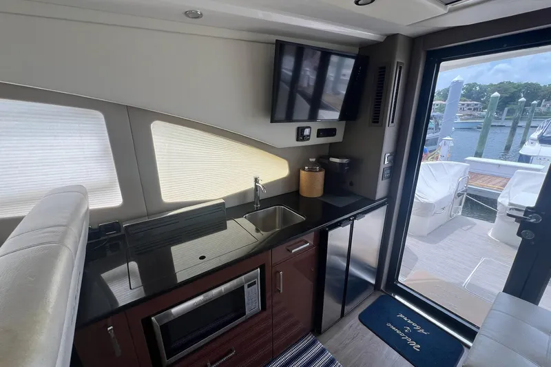 Slide: The Image of Luxurious interior of 2019 Carver C37 yacht with kitchenette and marina view. - 23