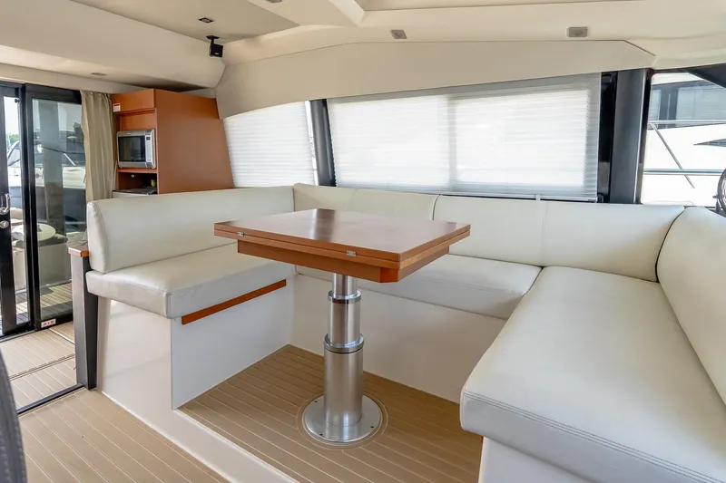 Slide: The Image of Luxurious interior of 2015 Prestige 450S yacht with white seating and wooden table. - 10
