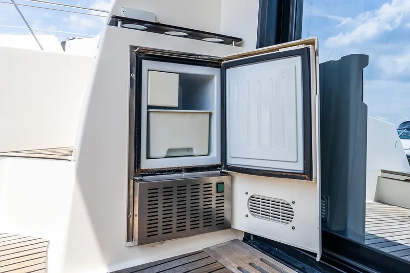 Slide: The Image of Open mini fridge on a 2015 Prestige 450S yacht, showcasing interior storage space. - 7