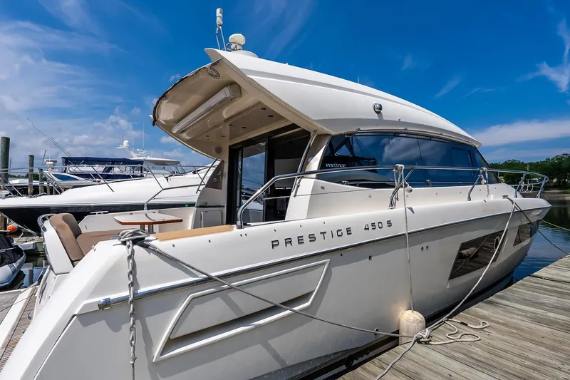 Slide: The Image of 2015 Prestige 450S yacht docked under a clear blue sky. - 1