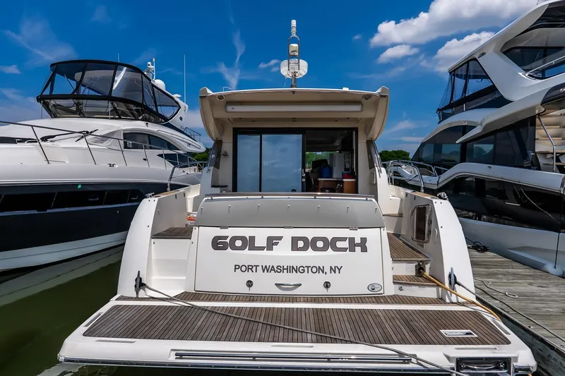 Slide: The Image of Prestige 450S yacht docked in Port Washington, NY, under a clear blue sky. - 2