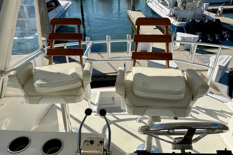 Slide: The Image of 1999 Ocean Yachts 45 Super Sport helm with cushioned seats and marina view. - 26