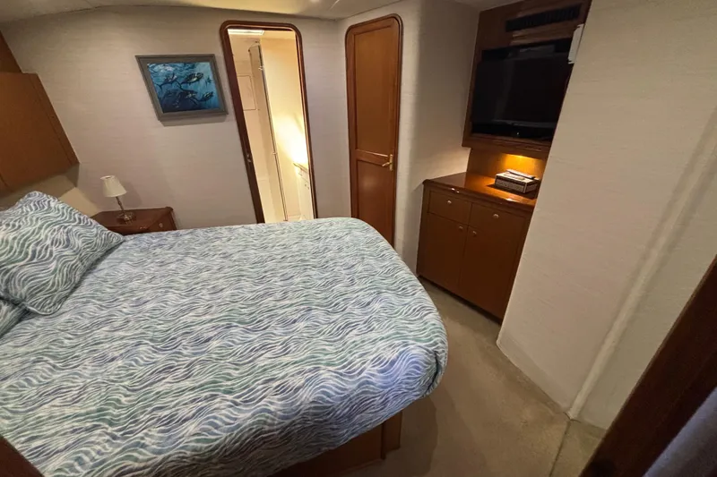 Slide: The Image of Cozy bedroom in 1999 Ocean Yachts 45 Super Sport with TV and nautical decor. - 16