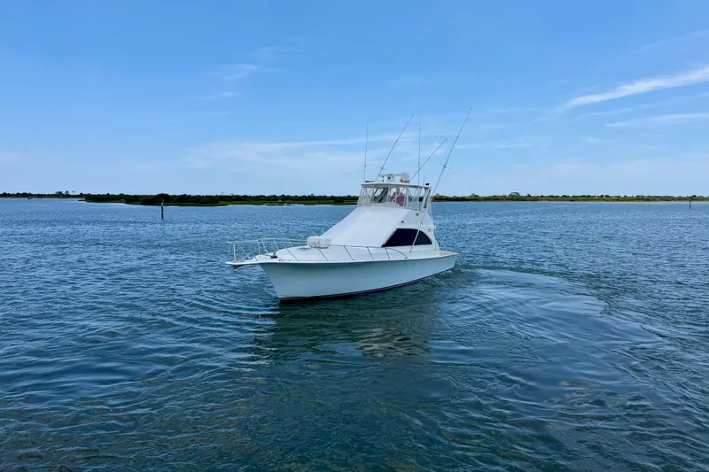 Slide: The Image of 1999 Ocean Yachts 45 Super Sport cruising on calm waters under a clear blue sky. - 3