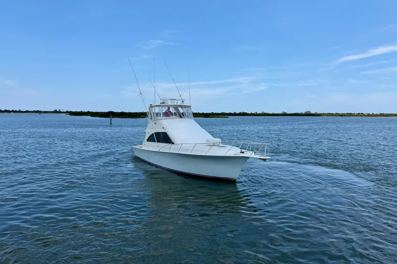 Slide: The Image of 1999 Ocean Yachts 45 Super Sport cruising on calm waters under a clear blue sky. - 2