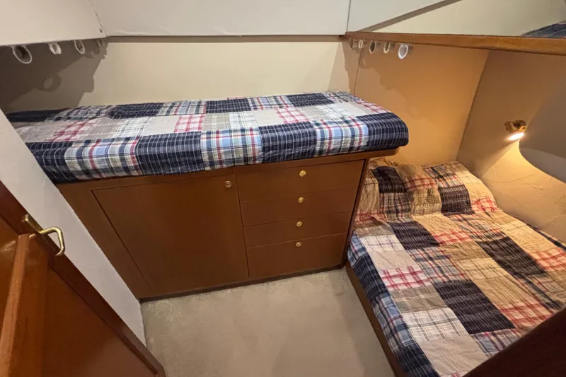Slide: The Image of 1999 Ocean Yachts 45 Super Sport cabin with twin beds and plaid bedding. - 19