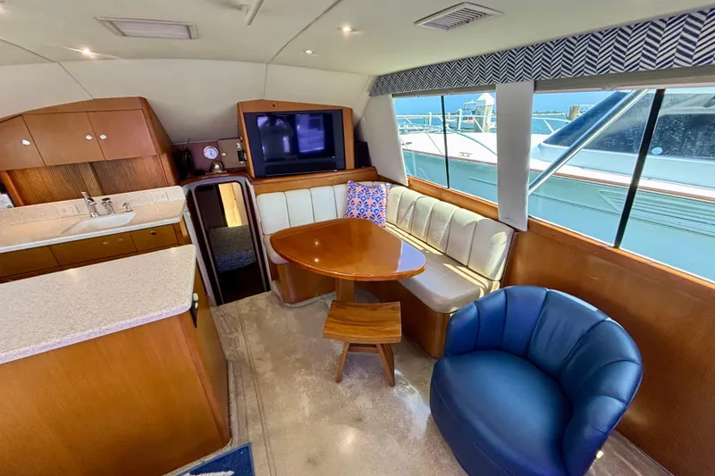 Slide: The Image of Interior of 1999 Ocean Yachts 45 Super Sport with seating, table, and kitchenette. - 10