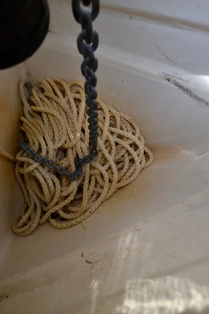 Slide: The Image of A rope is coiled on the floor of a white boat. - 35