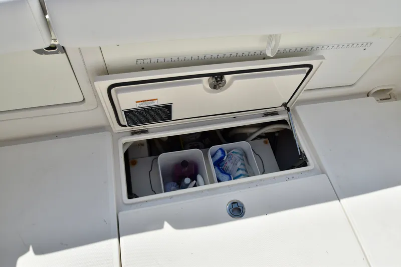 Slide: The Image of An open storage compartment on a 2015 Jupiter Center Console boat with drinks and water bottles. - 37