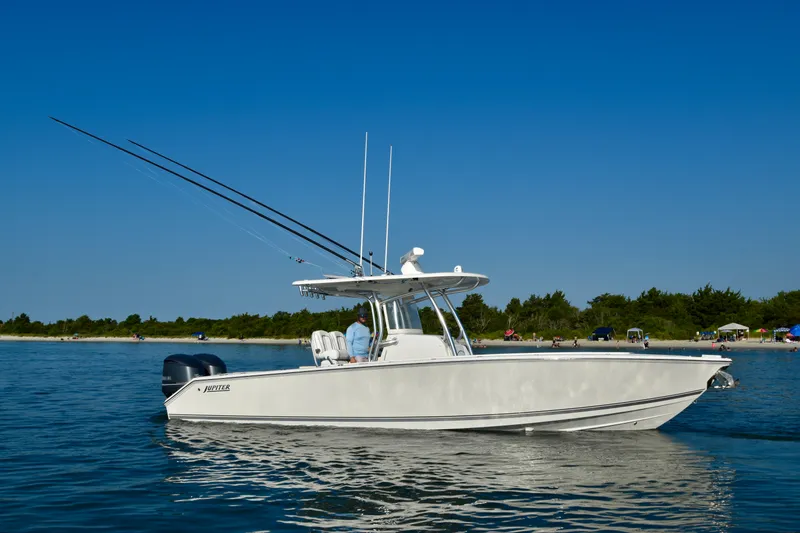 Slide: The Image of A white 2015 Jupiter Center Console boat on calm water, with fishing rods and clear skies. - 8