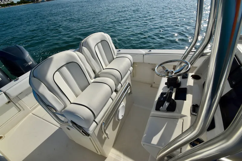 Slide: The Image of The image shows the cockpit of a 2015 Jupiter Center Console boat with white seating. - 21