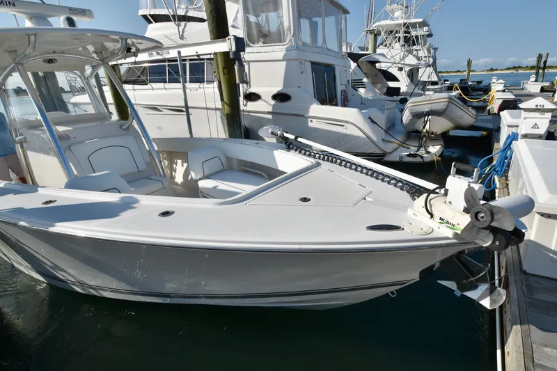 Slide: The Image of A 2015 Jupiter Center Console boat docked. It features a sleek, white design. - 27