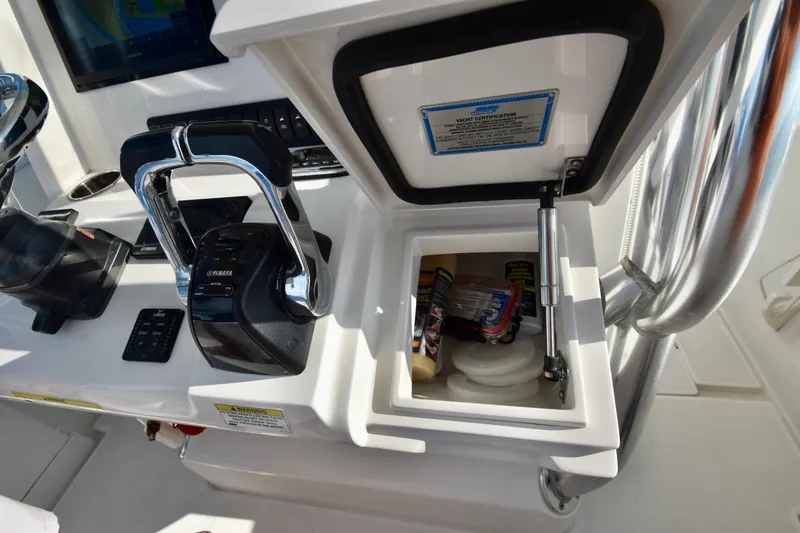 Slide: The Image of The image shows the helm of a Jupiter Center Console boat with levers and an open storage compartment. - 24