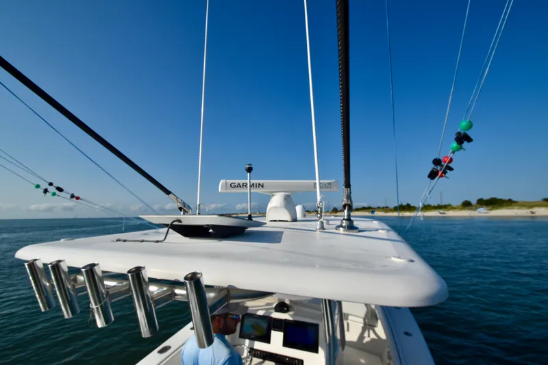 Slide: The Image of A 2015 Jupiter Center Console boat with rod holders and navigation equipment on the roof. - 16