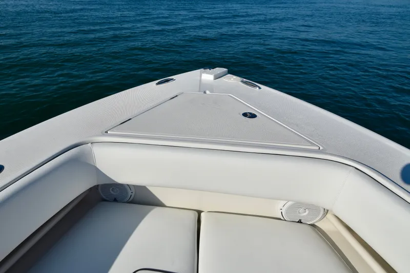 Slide: The Image of The bow of a white boat with cushioned seating and speakers, surrounded by blue water. - 9