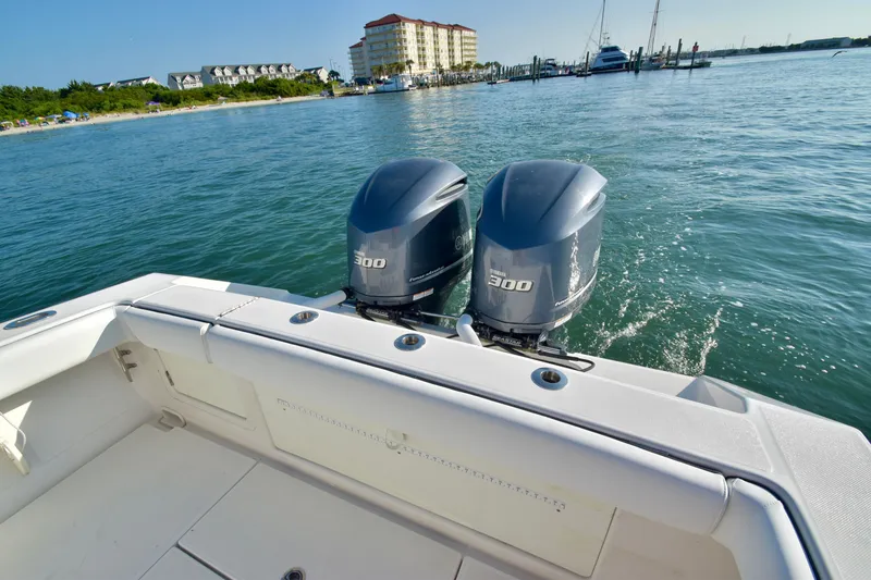 Slide: The Image of A 2015 Jupiter Center Console boat with twin powerful outboard engines on calm waters. - 11