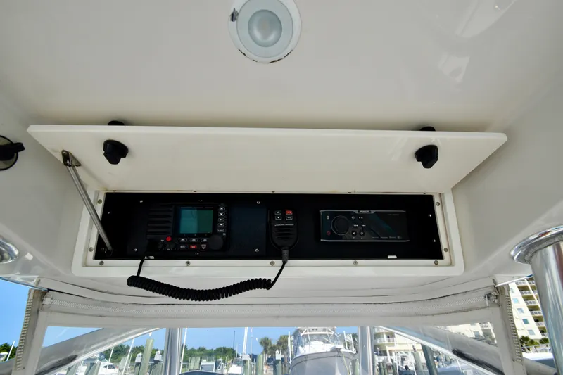 Slide: The Image of A 2015 Jupiter Center Console boat with an open electronics compartment showing radios and controls. - 42