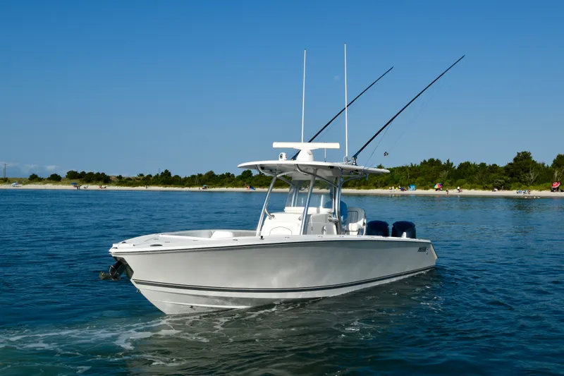 Slide: The Image of A white 2015 Jupiter Center Console boat cruising on calm waters near a shoreline. - 5