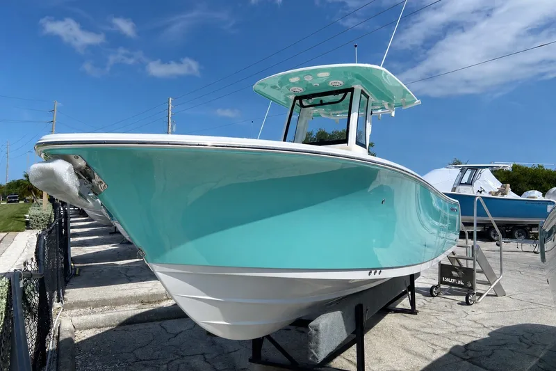 The Image of 2026 Sportsman Heritage 261 Center Console boat in vibrant turquoise, displayed outdoors. - 0