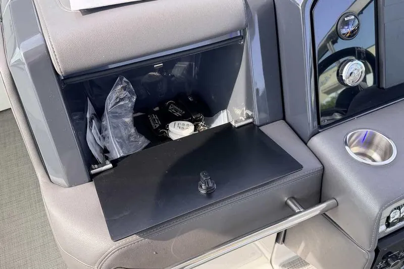 Slide: The Image of 2022 Formula 330 Crossover Bowrider I/O dashboard storage compartment with cup holder and controls. - 35