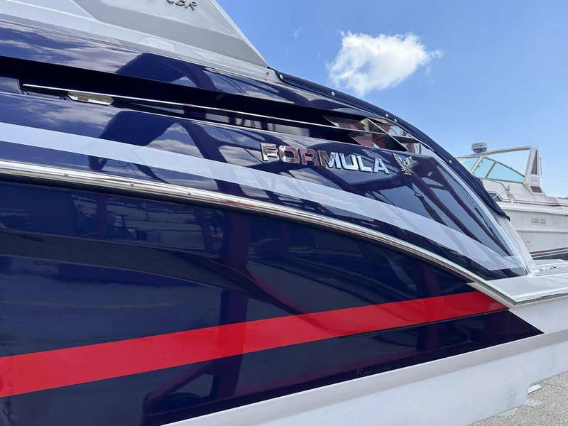 Slide: The Image of Close-up of the sleek hull of a 2022 Formula 330 Crossover Bowrider with distinctive stripes. - 3