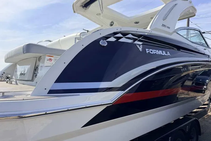 Slide: The Image of 2022 Formula 330 Crossover Bowrider I/O boat, sleek design, docked outdoors. - 2