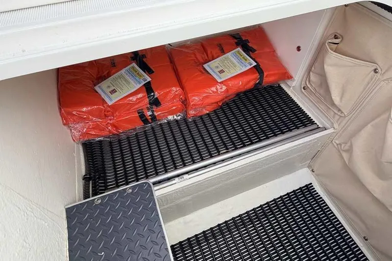 Slide: The Image of Storage compartment with life jackets in a 2022 Formula 330 Crossover Bowrider I/O boat. - 37