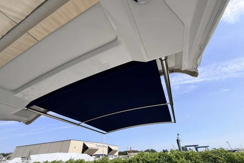 Slide: The Image of 2022 Formula 330 Crossover Bowrider I/O with extended sunshade under clear blue sky. - 11