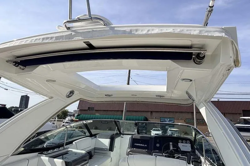 Slide: The Image of 2022 Formula 330 Crossover Bowrider I/O boat interior with open sunroof and modern dashboard. - 6