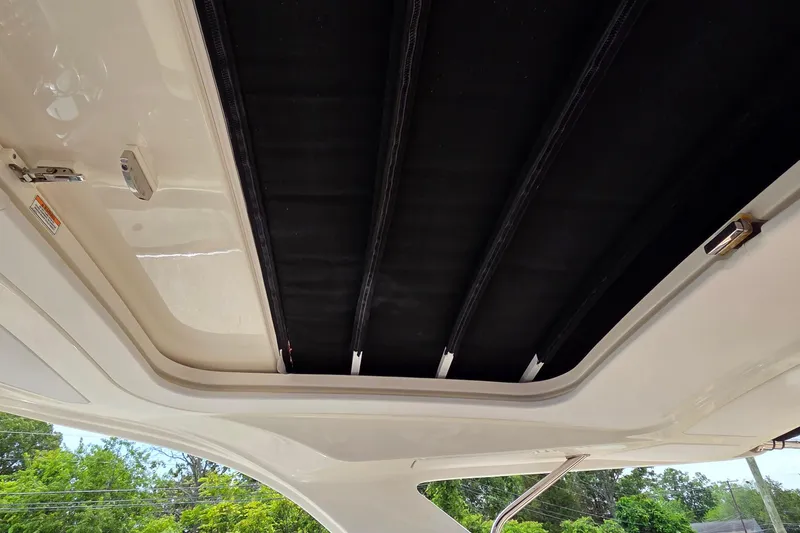 Slide: The Image of 2016 Sea Ray SLX 350 sunroof interior view with open canopy. - 25