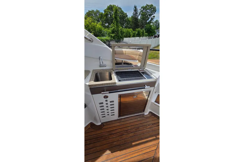 Slide: The Image of Outdoor kitchen on 2016 Sea Ray SLX 350 boat with grill and sink. - 13