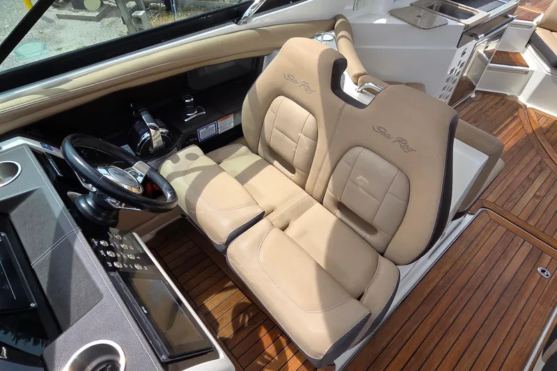 Slide: The Image of 2016 Sea Ray SLX 350 cockpit with beige leather seats and wooden flooring. - 10