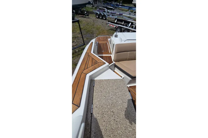 Slide: The Image of 2016 Sea Ray SLX 350 boat interior with teak flooring and beige seating. - 14