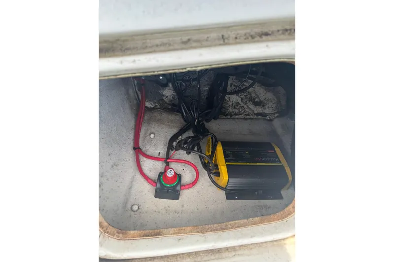 Slide: The Image of 2014 Carolina Skiff 198 DLV battery compartment with wiring and charger. - 11