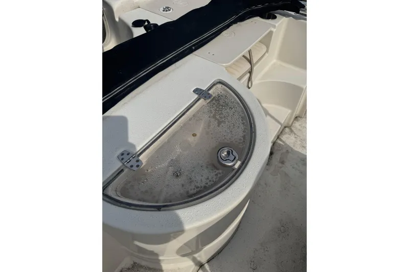 Slide: The Image of 2014 Carolina Skiff 198 DLV boat interior with storage compartment and latch. - 9