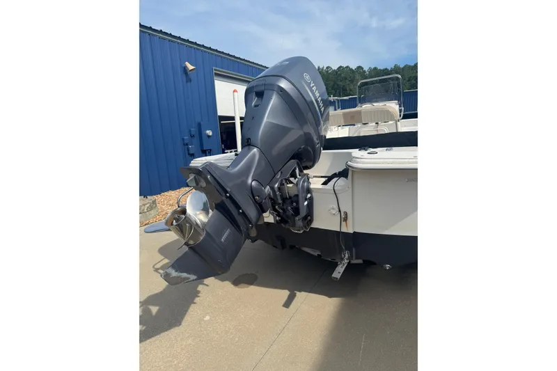 Slide: The Image of 2014 Carolina Skiff 198 DLV boat with Yamaha outboard motor, parked outdoors. - 3