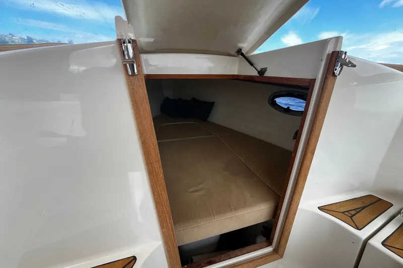Slide: The Image of Cozy cabin interior of 2013 AdmiralsTender C28 boat with wooden accents and porthole view. - 19