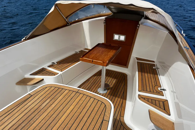 Slide: The Image of 2013 AdmiralsTender C28 boat interior with wooden deck and seating area. - 13