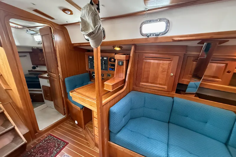 Slide: The Image of Interior of 2000 Tartan 3700 sailboat with wooden cabinetry and blue seating. - 23