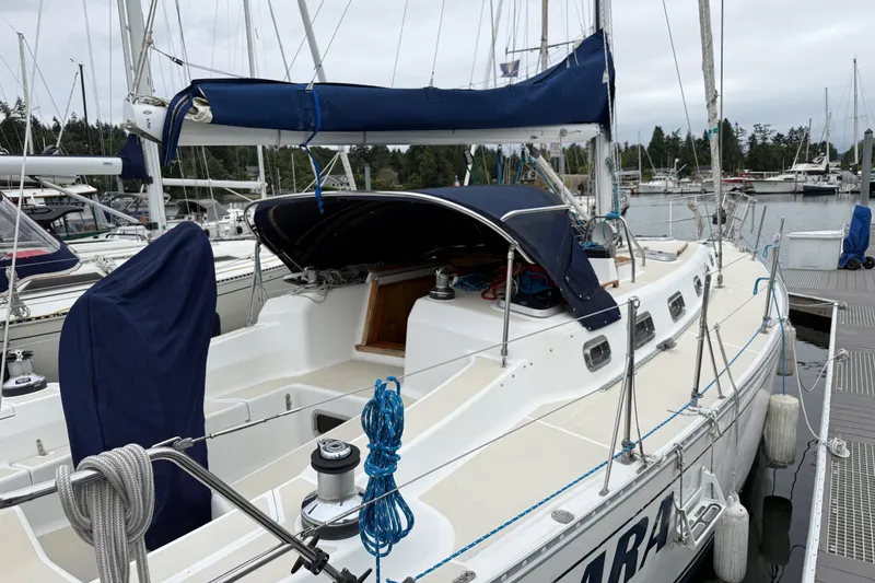 Slide: The Image of Sailboat Tartan 3700, 2000 model, docked at marina with blue covers. - 1