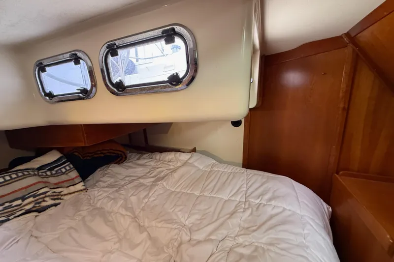 Slide: The Image of Cozy cabin interior of 2000 Tartan 3700 sailboat with portholes and bedding. - 21