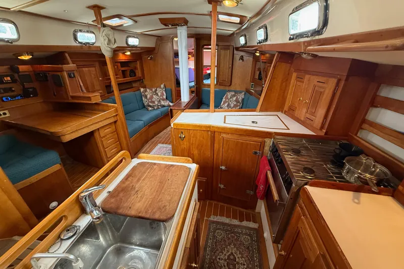 Slide: The Image of Interior of a 2000 Tartan 3700 sailboat with wooden cabinetry and cozy seating. - 8