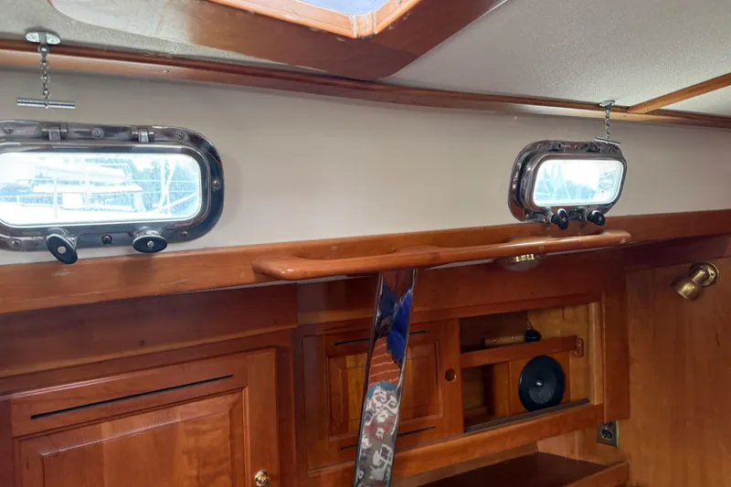 Slide: The Image of Interior of a 2000 Tartan 3700 sailboat with wooden cabinetry and portholes. - 9